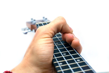 Hand grabbing a wooden ukulele on white background