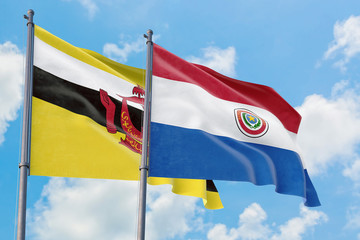 Paraguay and Brunei flags waving in the wind against white cloudy blue sky together. Diplomacy concept, international relations.