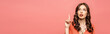 © LIGHTFIELD STUDIOS - panoramic shot of thoughtful young woman showing idea gesture while looking up isolated on pink