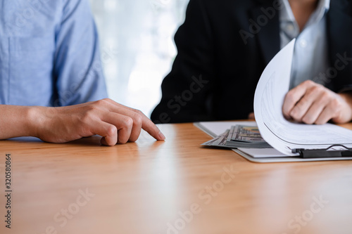 Fotografía Two business people taking bribe passing money under document sheets