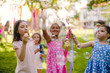 © Halfpoint - Small children standing outdoors in garden in summer, playing.