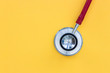 Red stethoscope on yellow background top view minimal doctor health concept