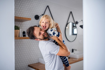 Wall Mural - Mature father with small son indoors in bathroom, having fun.