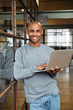 © Drobot Dean - Image of bald african american man holding laptop while working in office
