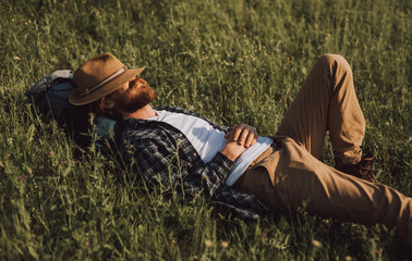 Wall Mural - Bearded explorer sleeping on grass