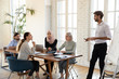 © fizkes - Male coach making flip chart presentation for multiracial colleagues