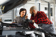 © Serhii - Male and female mechanics working on car