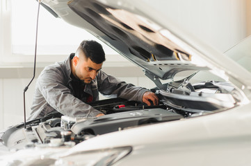 Mechanic working and holding wrench of service order for maintaining car at the repair shop