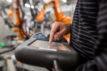 Technician man programming robot in automotive industrial, professional programmer, industry concept