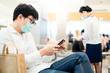 © zephyr_p - Male Asian patient wearing surgical mask using smartphone in hospital or medical center. Medical exam or body check up. Wuhan coronavirus (COVID-19) outbreak prevention. Health care concept