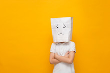 Cute Little School Boy Standing With A Paper Bag On His Head - Sad Face On Yellow Background, Concept