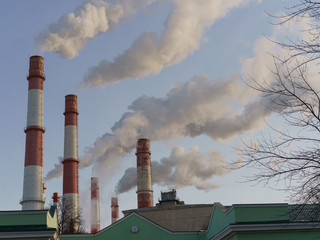 Industrial Moscow. Heat station pipes and smoke. Smoking pipes, white smoke with blue sky as background in winter. Chimneys, concept of industry and ecology, heating season, modern global warming.