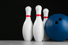 Blue Bowling Ball And Pins On Light Grey Marble Table