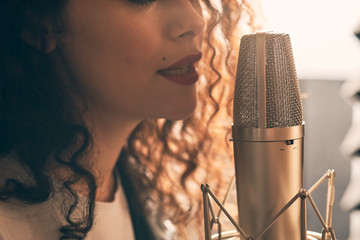 Wall Mural - Pretty female singer recording in music studio