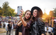 © Indico Studio/ADDICTIVE STOCK - Charming cheerful friends in black hat having fun grimacing and taking selfie on mobile phone in bright day at festival