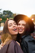 © Indico Studio/ADDICTIVE STOCK - Charming long haired stylish girl friends confidently looking at camera in bright day at festival