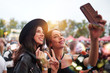 © Indico Studio/ADDICTIVE STOCK - Charming cheerful friends in black hat having fun grimacing and taking selfie on mobile phone in bright day at festival