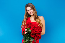 Tender Girl With Bouquet Of Red Roses Posing On Blue Background