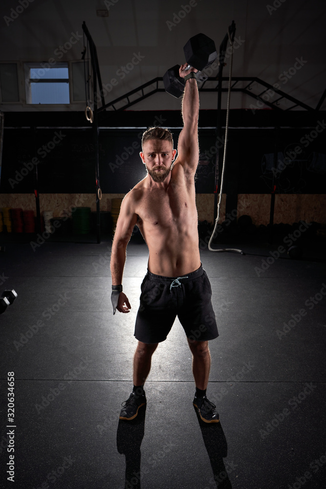 Man Using Strength Strong man with dumbbell in his hand doing strength exercises in the ...