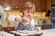 © PHILIPPE DEGROOTE/ADDICTIVE STOCK - Stock photo of a boy with apron pouring cream on plates prepared to make cupcakes