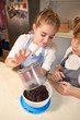 © PHILIPPE DEGROOTE/ADDICTIVE STOCK - Stock vertical photo of a girl wearing an apron pouring the content of a container into a bowl