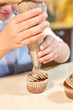 © PHILIPPE DEGROOTE/ADDICTIVE STOCK - Stock vertical photo of the detail of the hand of a girl decorating cupcakes with cream with a pastry sleeve with the help of a woman