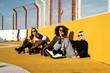© Rafa Cortes/ADDICTIVE STOCK - Focused young diverse women in trendy clothes and sunglasses looking at camera while sitting during friendly meeting on stadium