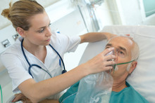 Female Doctor Applying Oxygen Mask On Senior Patient