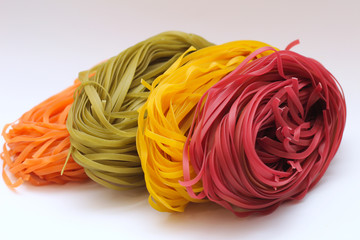 Isolated colored spaghetti nests on a white background.