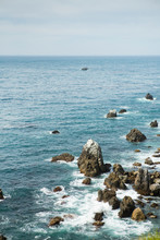 Blue Waters Of The Pacific Ocean With Sharp Rocks Scattered In Big Sur California.