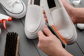 Wall Mural - Man cleaning leather loafers, removing dirt with a brush and foam