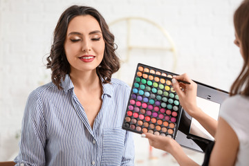 Sticker - Makeup artist working with beautiful young woman in salon