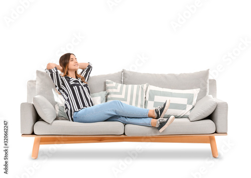 Cuadros en Lienzo Young woman relaxing on sofa against white background