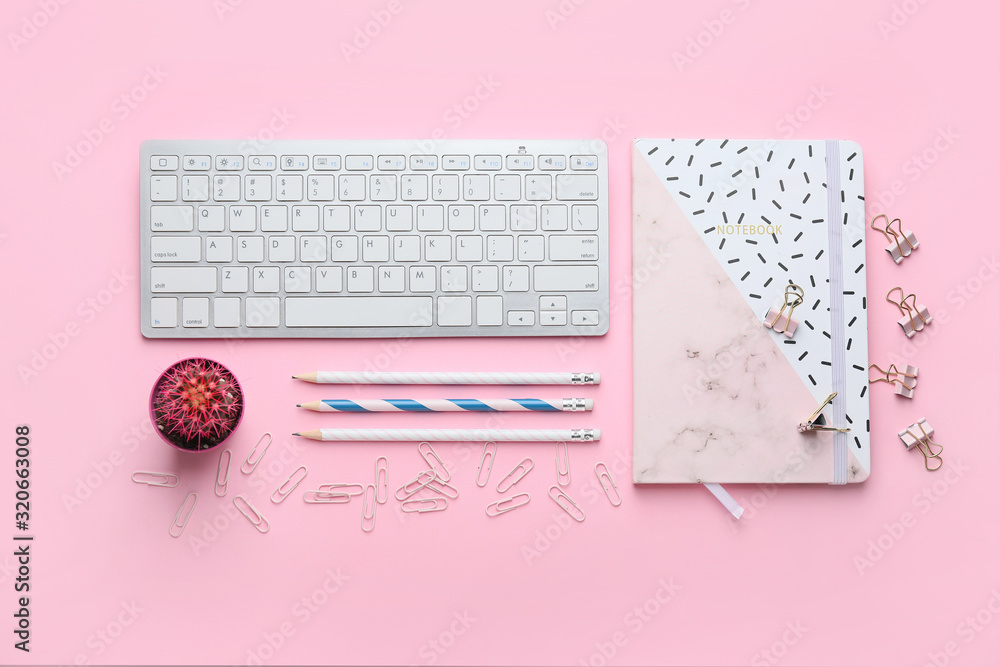 Composition with PC keyboard and stationery on pink background