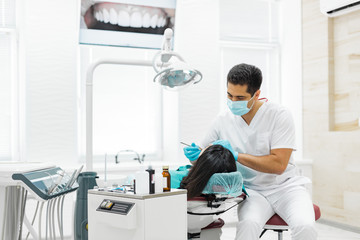 Cute young girl is being examined by the dentist