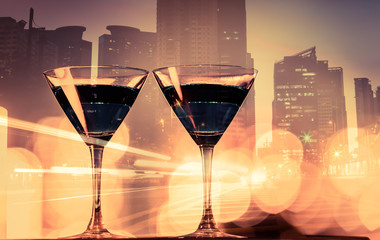 Wall Mural - Martini drink on city background. Bar menu, cosmopolitan, and night life background. 