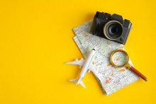 Travel Accessories On Yellow Background. Vintage Camera, Airplane, Magnifying Glass And Map. Minimalist Flat Lay Style Composition, Top View. Travel Planning Concept