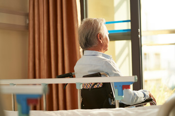 Sticker - asian old man sitting in wheel chair in nursing home looking out of window