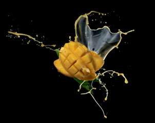 Wall Mural - mango slice and mango juice splash wave isolated on a black background