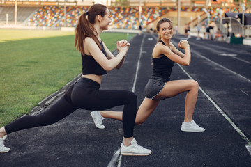 Wall Mural - Beautiful girls at the stadium. Sports girl in a sportswear. Frends training