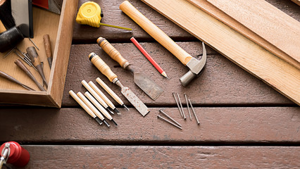 Wall Mural - Carpenter working with equipment on wooden table in carpentry shop. woman works in a carpentry shop.