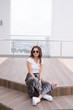 © makistock - Beautiful young Asian woman wearing fashionable clothes sitting on stairs