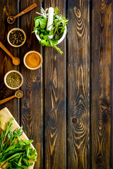 Wall Mural - Making spices. Herbs in motar and dry flavorings on dark wooden desk top-down copy space