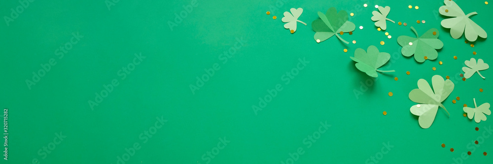 St. Patrick's day, clover on a green shiny background - obrazy, fototapety, plakaty 