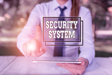 Conceptual hand writing showing Security System. Concept meaning system designed to detect intrusion or unauthorized entry Female business person sitting by table and holding mobile phone