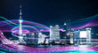 Night city with abstract gradient blue and red glowing light trail surround the city ,Smart city big data connection technology concept .