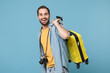 © ViDi Studio - Cheerful traveler tourist man in yellow summer casual clothes with photo camera isolated on blue background. Male passenger traveling abroad on weekends. Air flight journey concept. Holding suitcase.