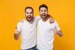 © ViDi Studio - Crazy young men guys friends in white blank empty t-shirts posing isolated on yellow orange wall background studio portrait. People lifestyle concept. Mock up copy space. Screaming, showing thumbs up.