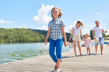 Wall Mural - Happy family is taking walk at the lake