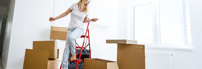 Wall Mural - People moving new place and repair concept happy young woman with many boxes